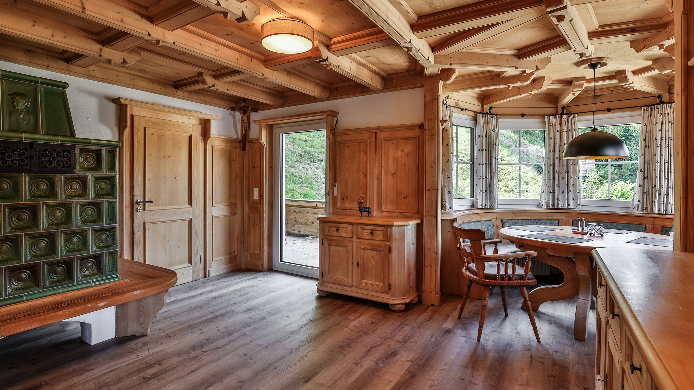 In der Ferienwohnung Hochkalter Blick zum Kachelofen, Essbereich und Balkon alles im alpenländlichen Stile